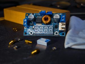 Close-up of an electronic circuit board with various components on a dark background. Ideal for tech themes.